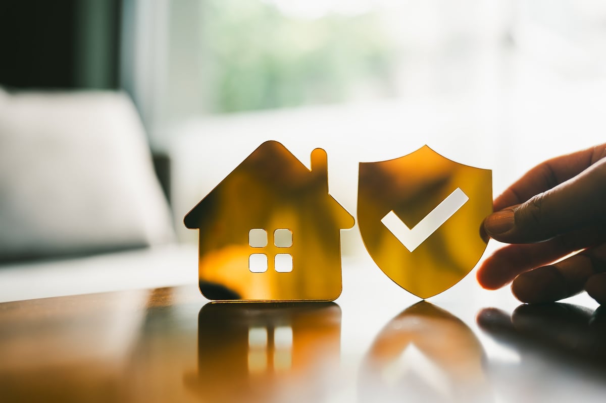 Golden shield and house symbol representing umbrella liability protection